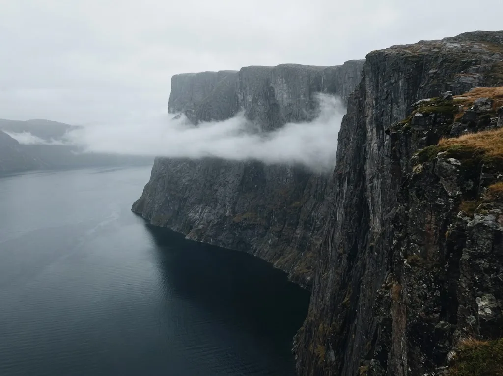 Artist's impression of a sheer cliff above the fjord, with cloud below its edge